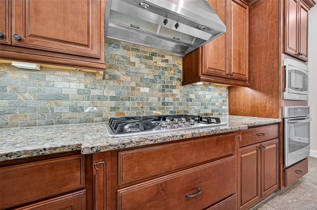 a kitchen with granite countertop cabinets stainless steel appliances and a counter space