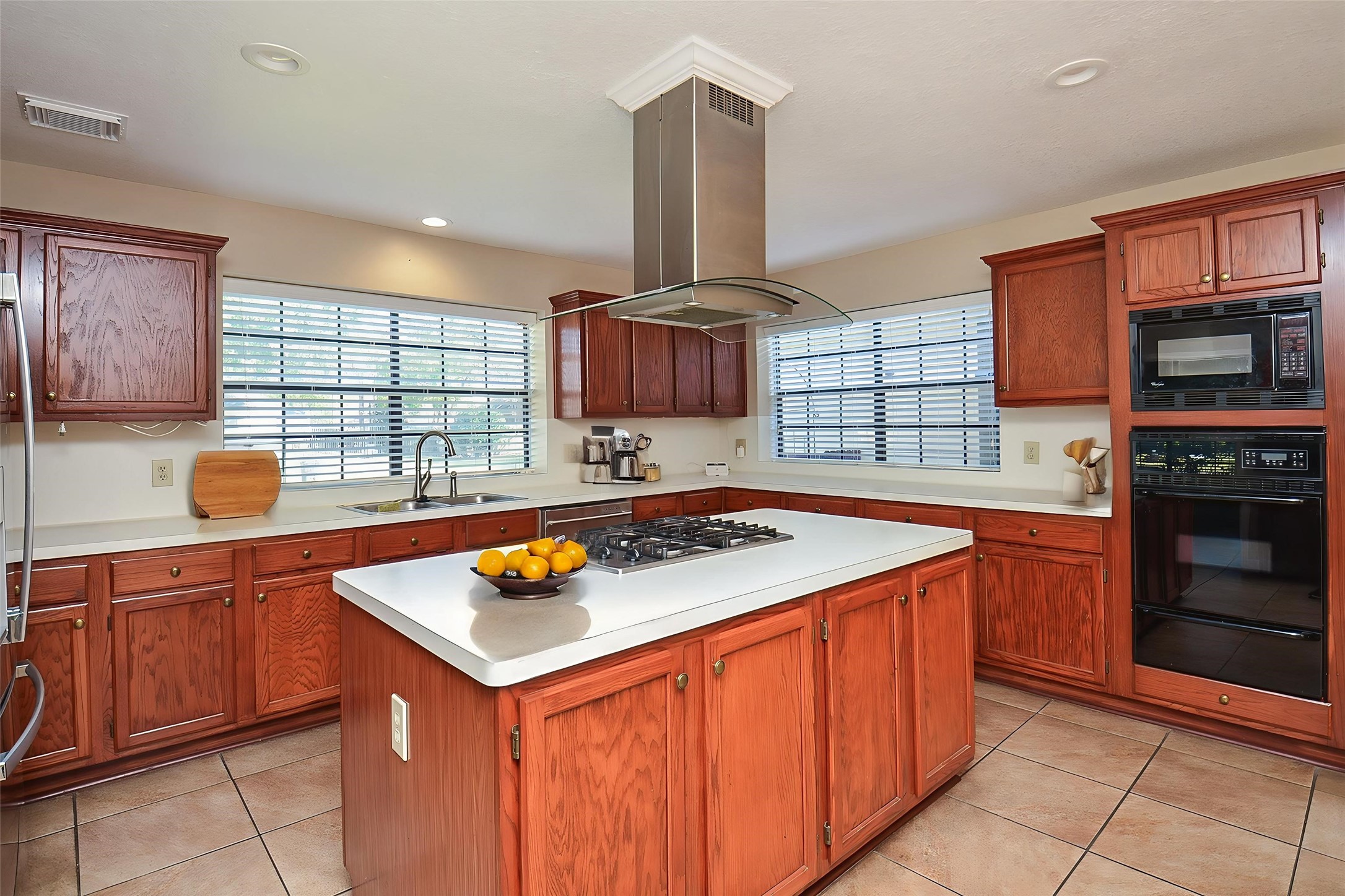 8803 Tweedbrook Drive Spring, TX 77379 - Photo 13 of 36 Observe the expansive island counter equipped with a stove cooktop and a newly installed elegant stainless steel pendant vent.