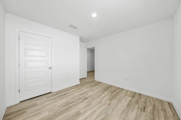 an empty room with a window and a ceiling fan