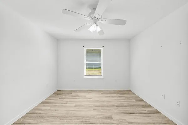 a view of a room with wooden floor and a ceiling fan