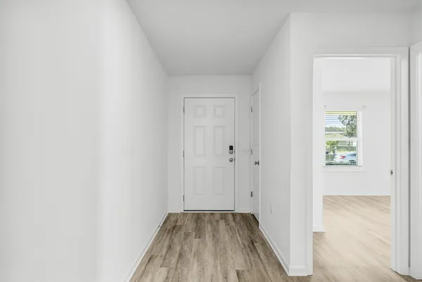 a view of a hallway with wooden floor