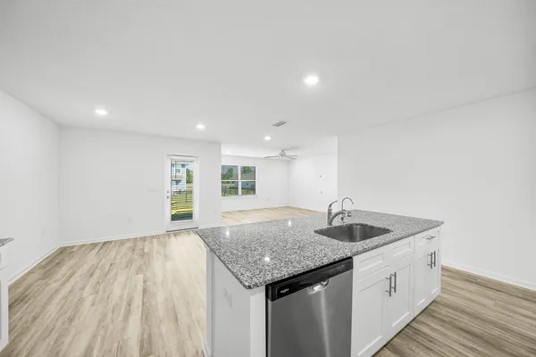 a view of a kitchen with wooden floor and a window