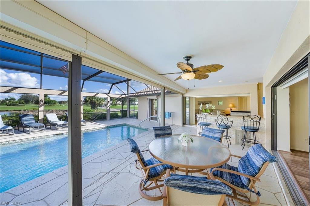1101 Foxfire Lane Naples, FL 34104 - Photo 11 of 38 a dining room with furniture a chandelier and wooden floor