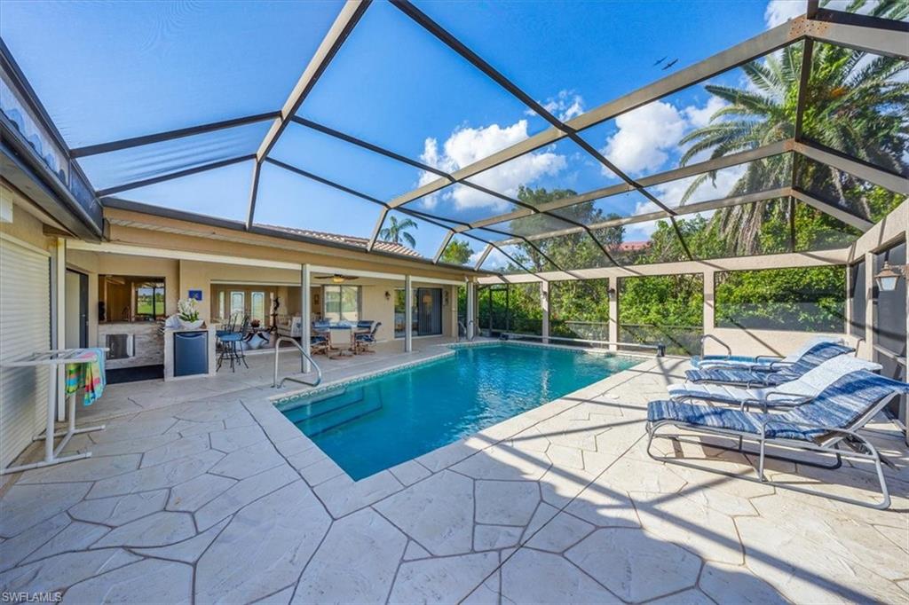 1101 Foxfire Lane Naples, FL 34104 - Photo 13 of 38 a view of a patio with swimming pool table and chairs