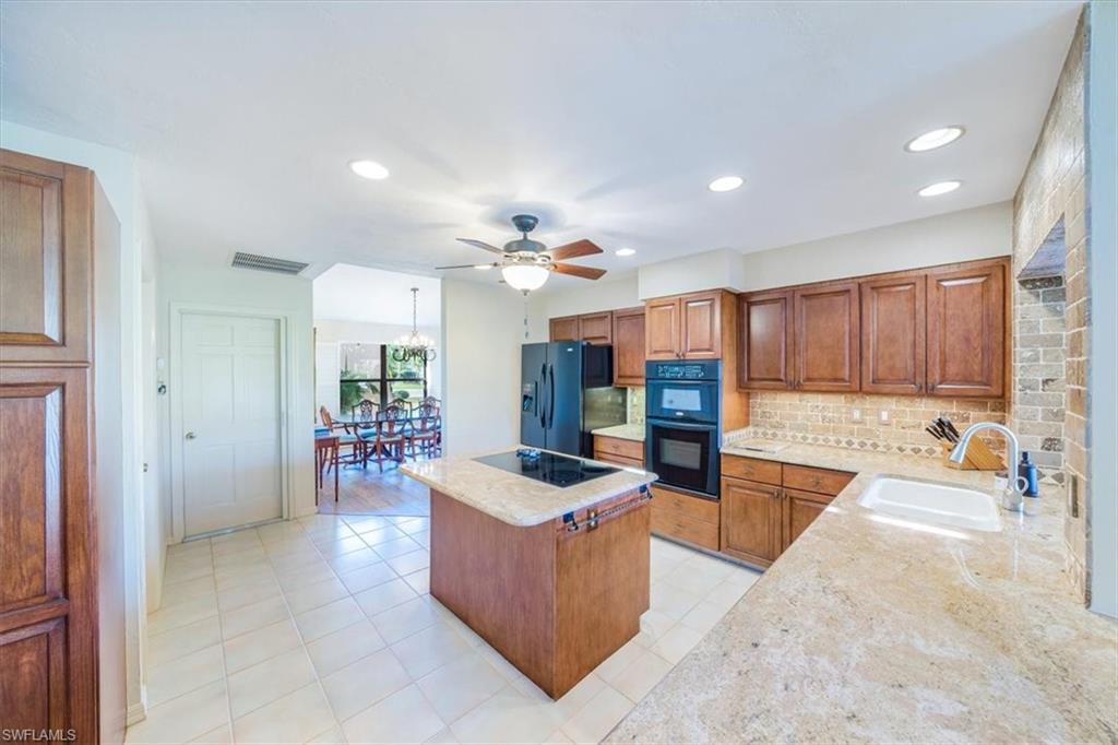 1101 Foxfire Lane Naples, FL 34104 - Photo 17 of 38 a large living room with stainless steel appliances kitchen island granite countertop a couch and a view of living room