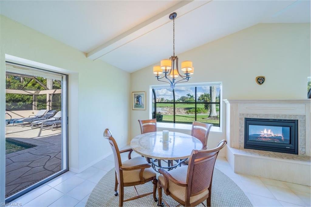 1101 Foxfire Lane Naples, FL 34104 - Photo 20 of 38 a dining room with furniture a chandelier and wooden floor