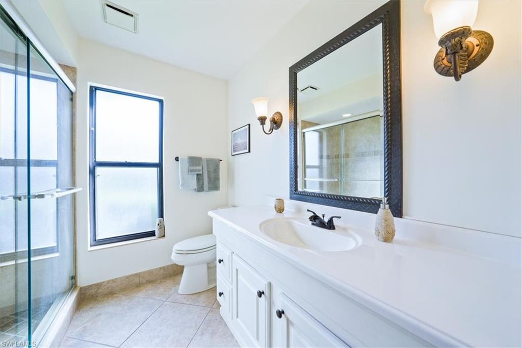 1101 Foxfire Lane Naples, FL 34104 - Photo 26 of 38 a bathroom with a sink a toilet and a mirror