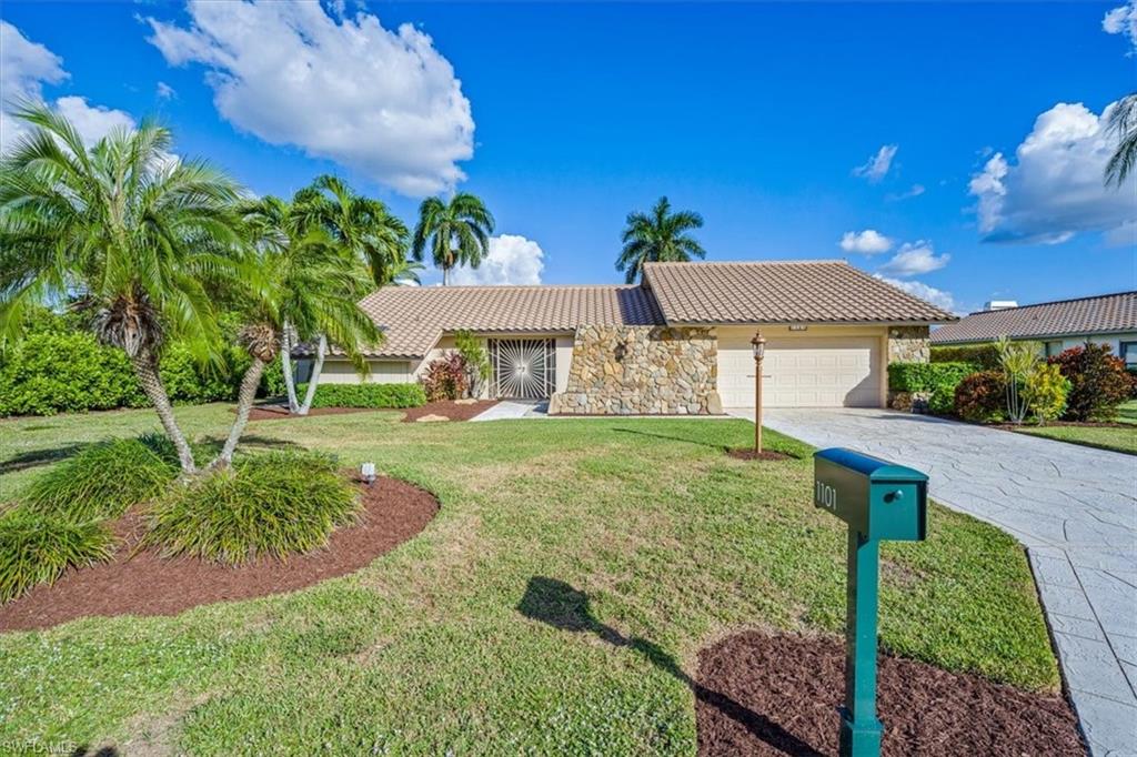1101 Foxfire Lane Naples, FL 34104 - Photo 28 of 38 a front view of a house with garden