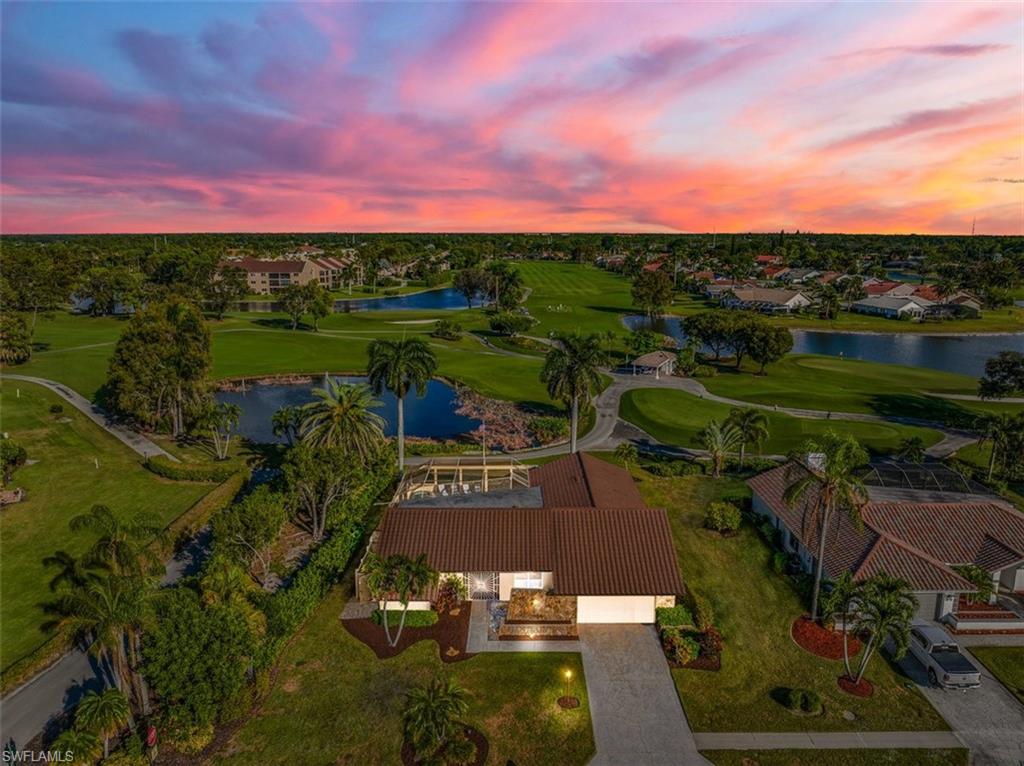 1101 Foxfire Lane Naples, FL 34104 - Photo 3 of 38 a view of a lake with a house in the background
