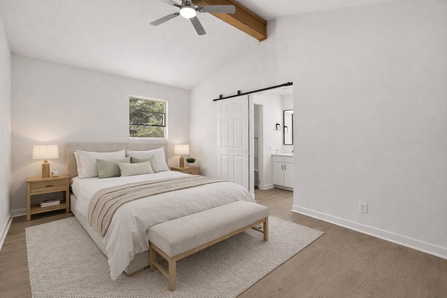 2204 Toro Canyon Road Austin, TX 78746 - Photo 17 of 26 Bedroom featuring a barn door, light wood-style floors, a ceiling fan, and ensuite bathroom