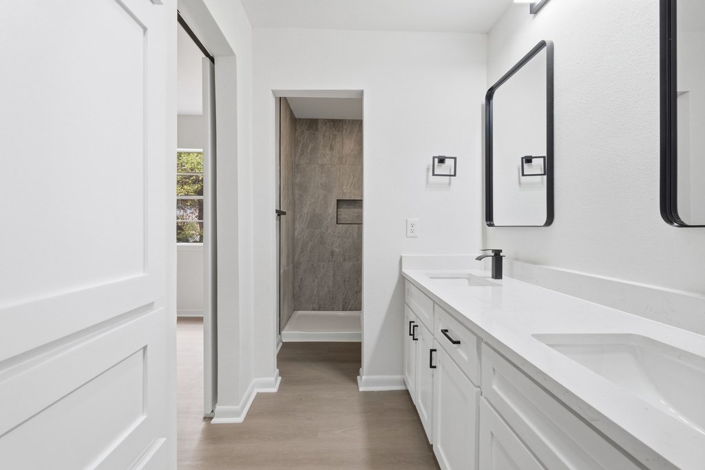 2204 Toro Canyon Road Austin, TX 78746 - Photo 21 of 26 Full bath featuring double vanity, a shower stall, and light wood-style flooring