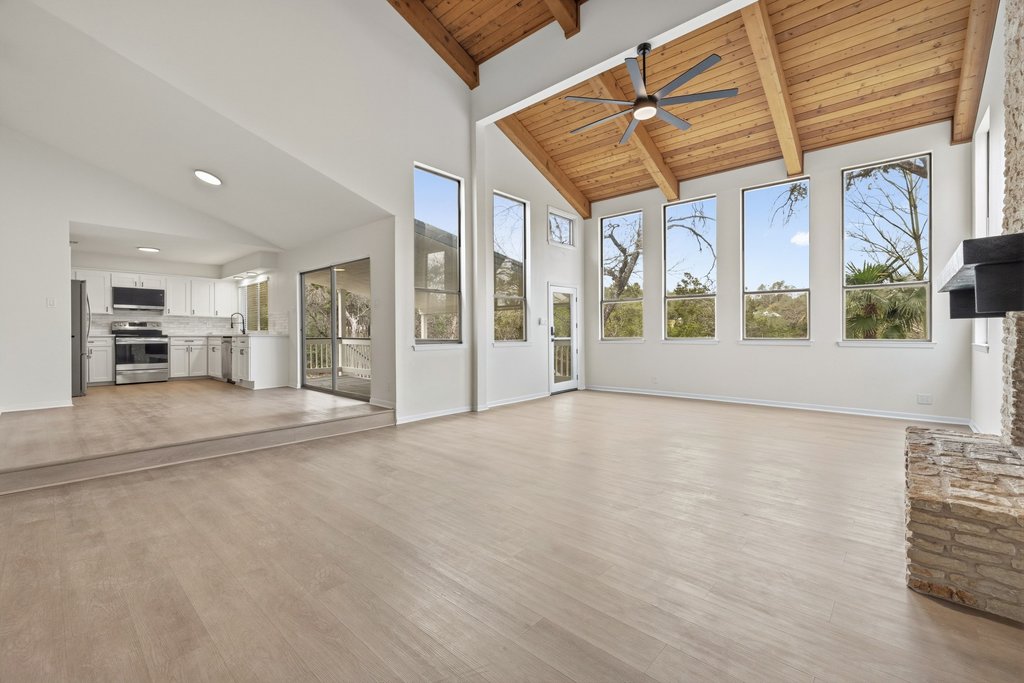2204 Toro Canyon Road Austin, TX 78746 - Photo 6 of 26 Unfurnished living room featuring a ceiling fan, light wood finished floors, and lofted ceiling