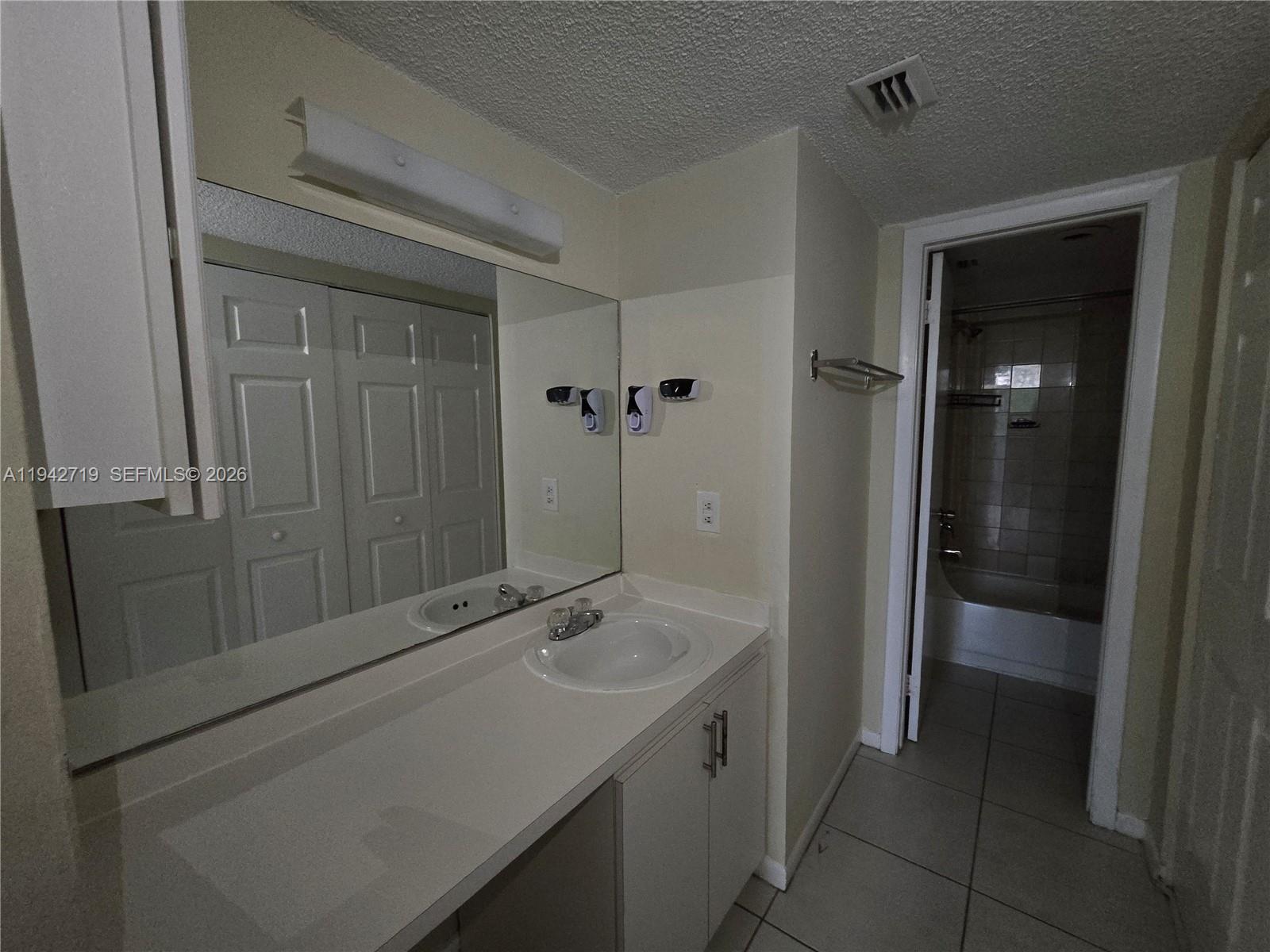 8215 Southwest 152nd Avenue, Unit G416 Miami, FL 33193 - Photo 11 of 17 a bathroom with a sink and mirror