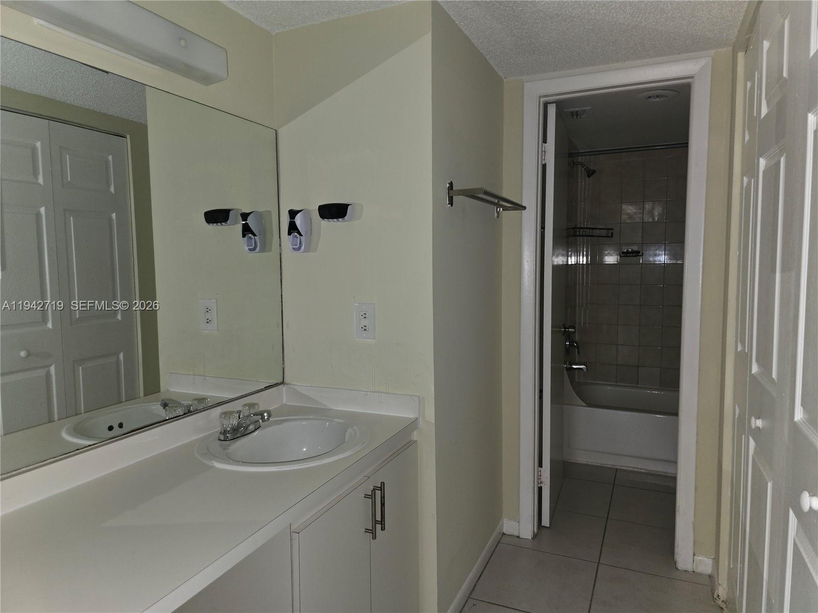 8215 Southwest 152nd Avenue, Unit G416 Miami, FL 33193 - Photo 13 of 17 a bathroom with a sink and mirror