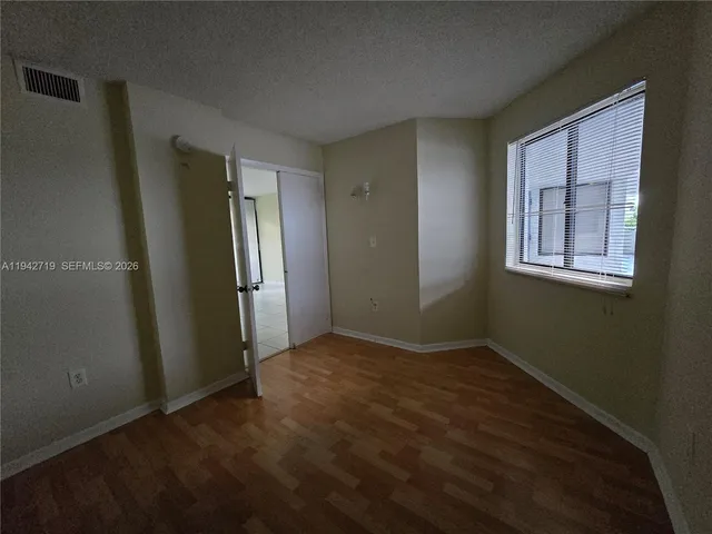 an empty room with windows and closet