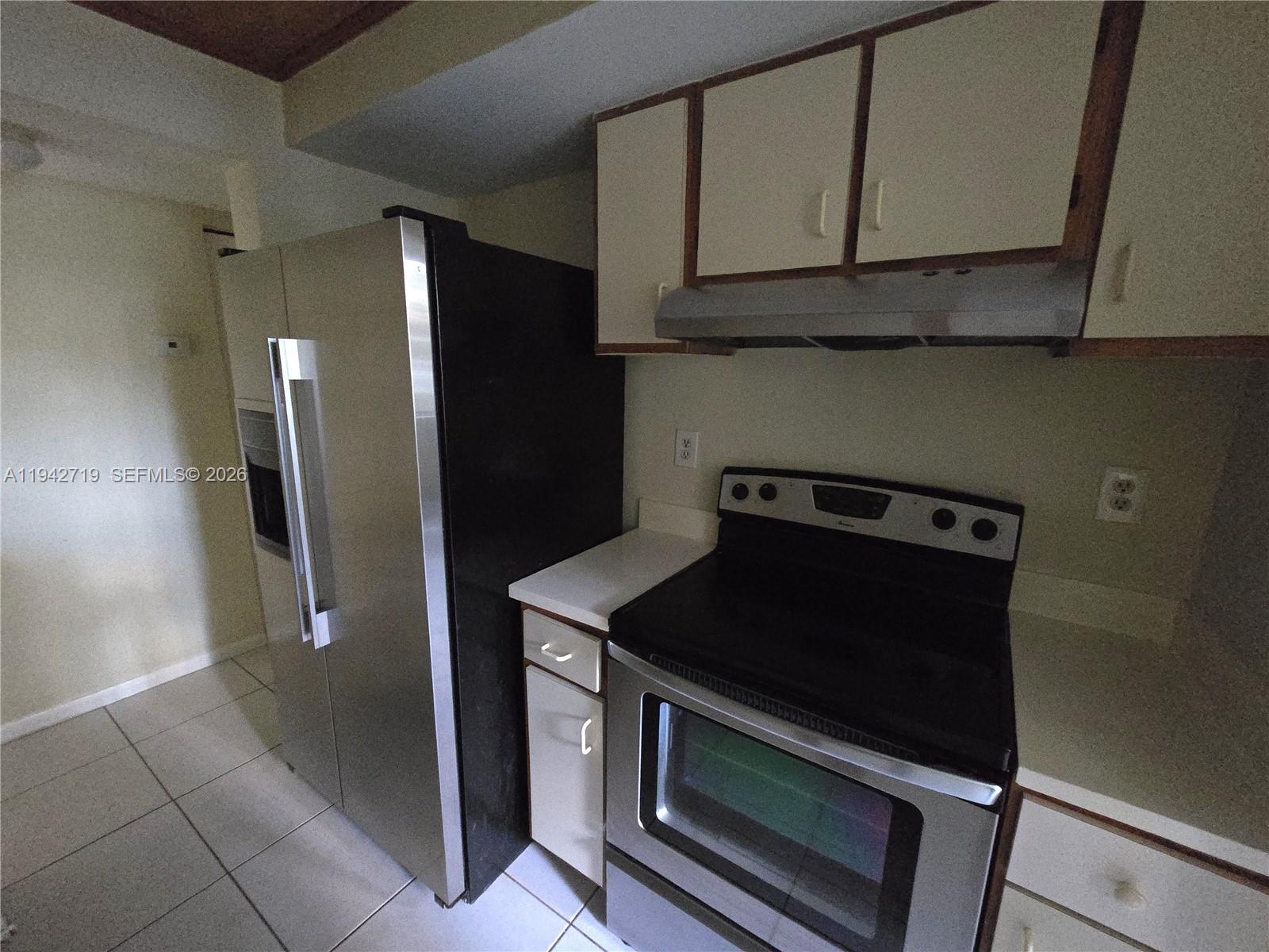 8215 Southwest 152nd Avenue, Unit G416 Miami, FL 33193 - Photo 10 of 17 a kitchen with stainless steel appliances granite countertop a refrigerator and a stove
