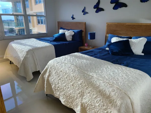 a bedroom with two beds and a potted plant