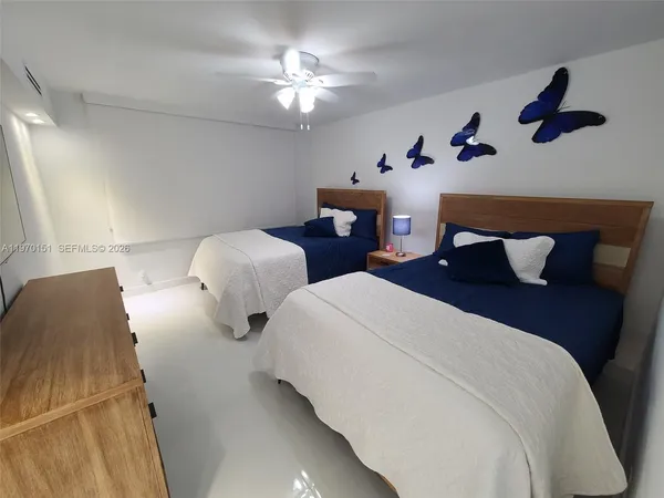 a bedroom with two beds and a chandelier