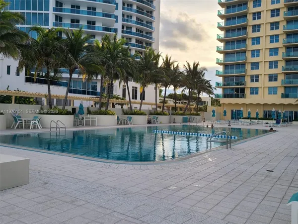 a view of a lake with a building and palm trees