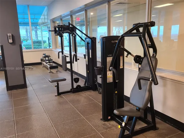 a room with gym equipment and large windows