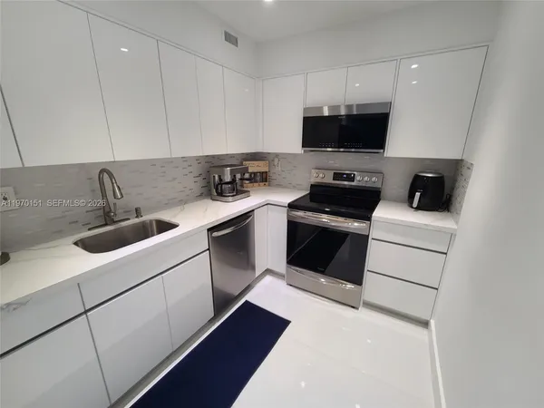 a kitchen with a sink and white cabinets