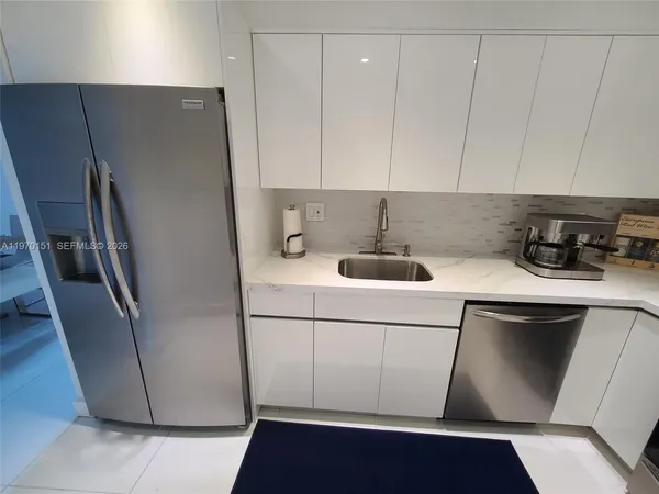 a kitchen with a refrigerator sink and cabinets
