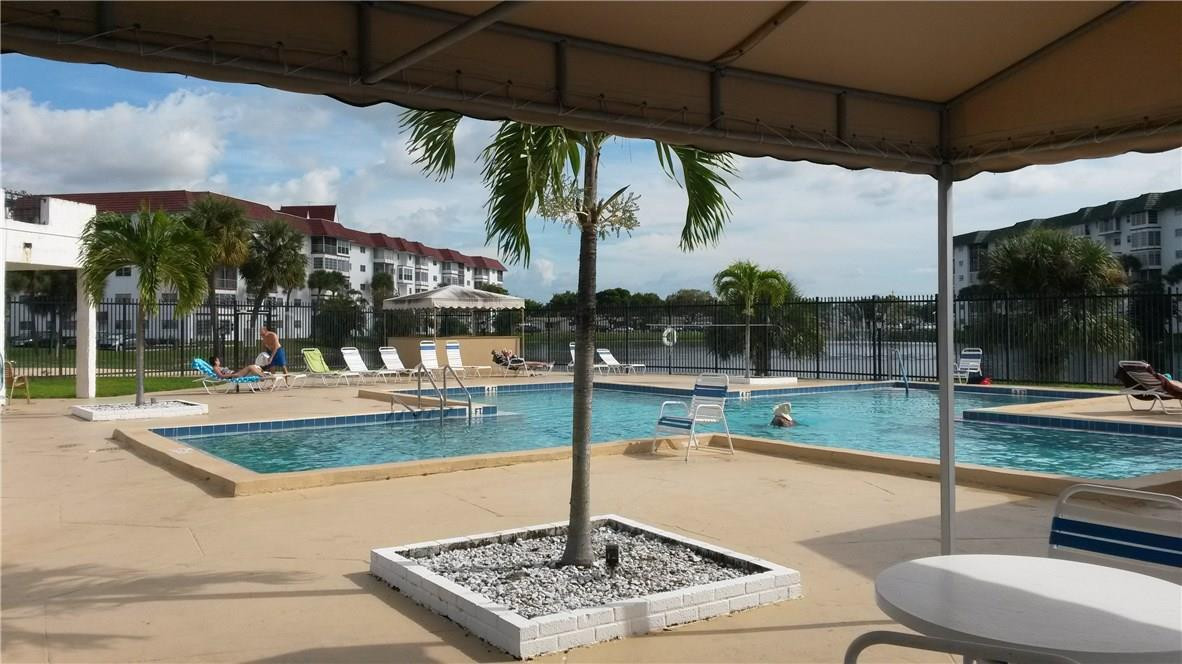 4880 Northwest 22nd Street, Unit 101 Lauderhill, FL 33313 - Photo 2 of 18 a view of a swimming pool with a porch