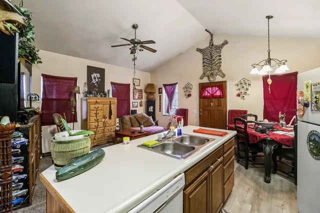 a kitchen that has a stove a microwave oven a dining table and chairs with the kitchen view