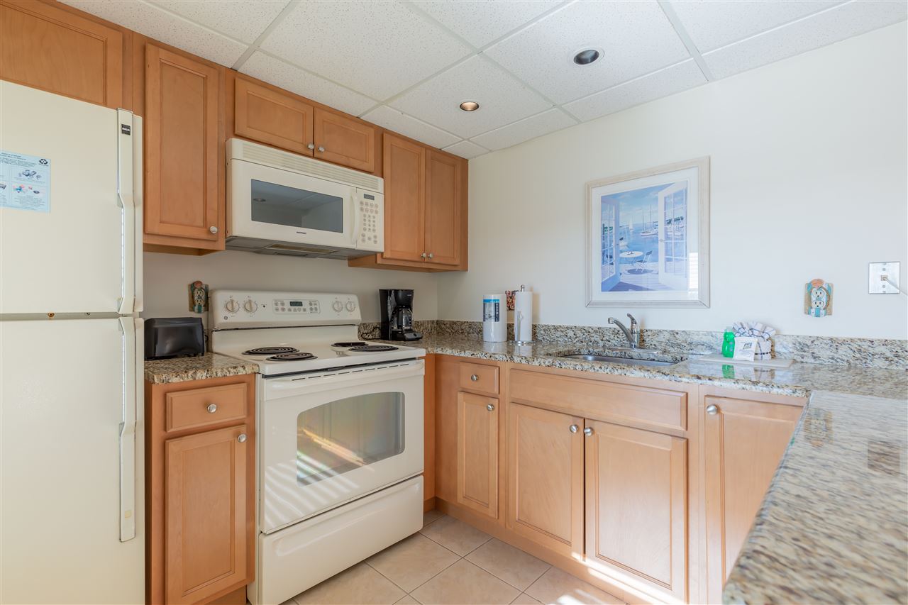 217 Beach, Unit 102 Cape May, NJ 08204 - Photo 12 of 30 a kitchen with stainless steel appliances granite countertop a sink and a refrigerator