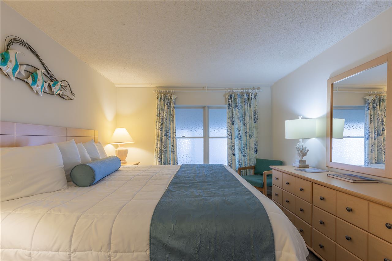 217 Beach, Unit 102 Cape May, NJ 08204 - Photo 19 of 30 a bedroom with a bed and a dresser
