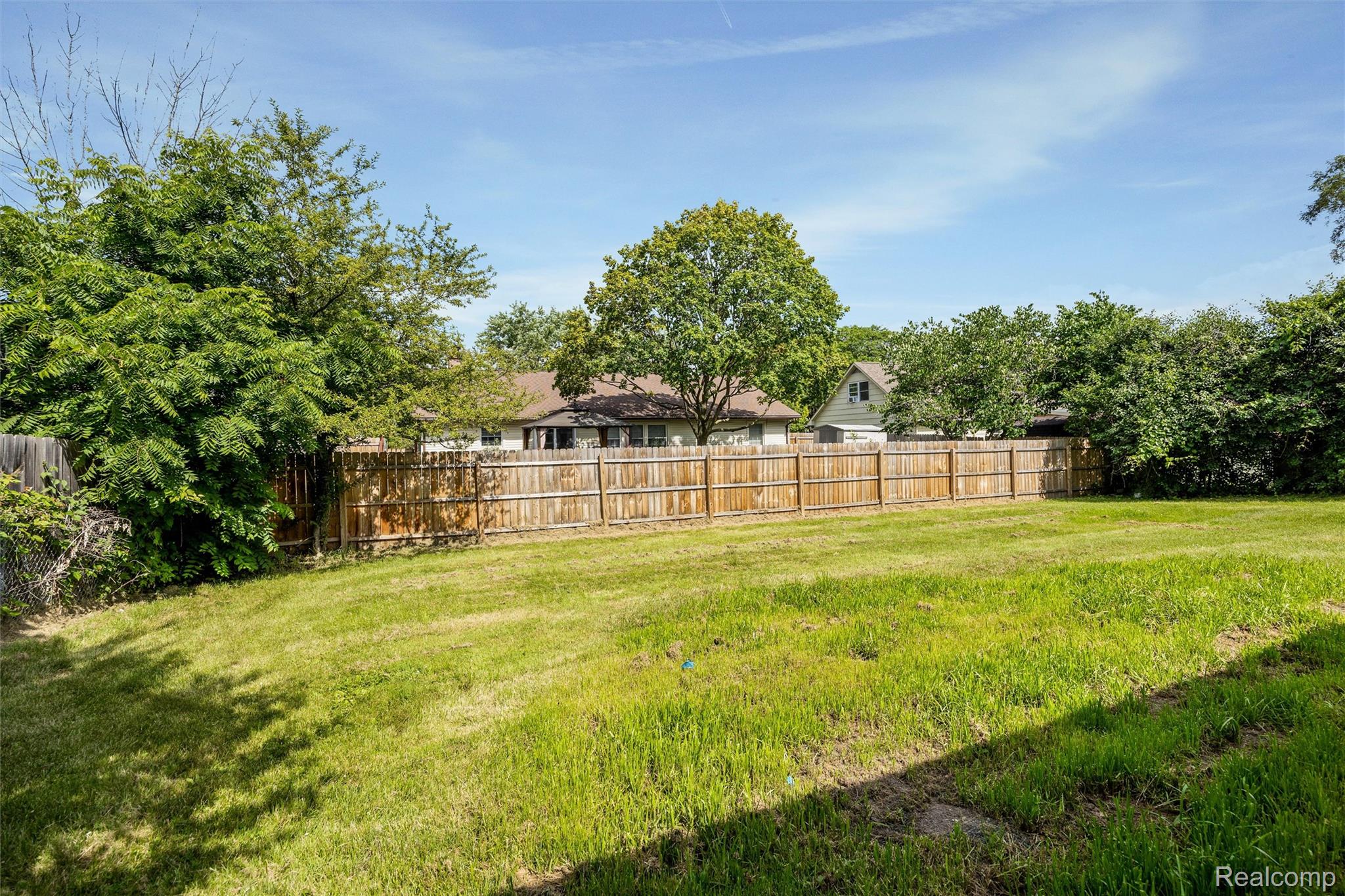 4942 Butler Drive Troy, MI 48085 - Photo 29 of 33 Expansive grassy yard area featuring a full wooden privacy fence and mature perimeter trees