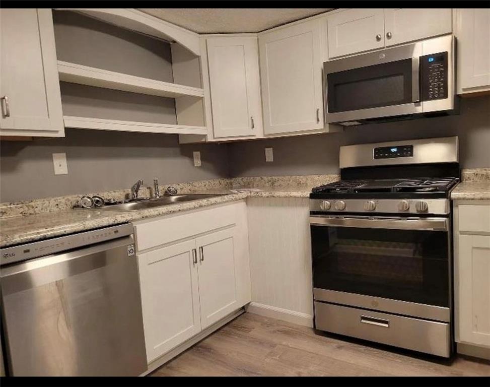169 Union Street Bridgeville, PA 15017 - Photo 6 of 23 a kitchen with stainless steel appliances granite countertop a stove microwave and cabinets