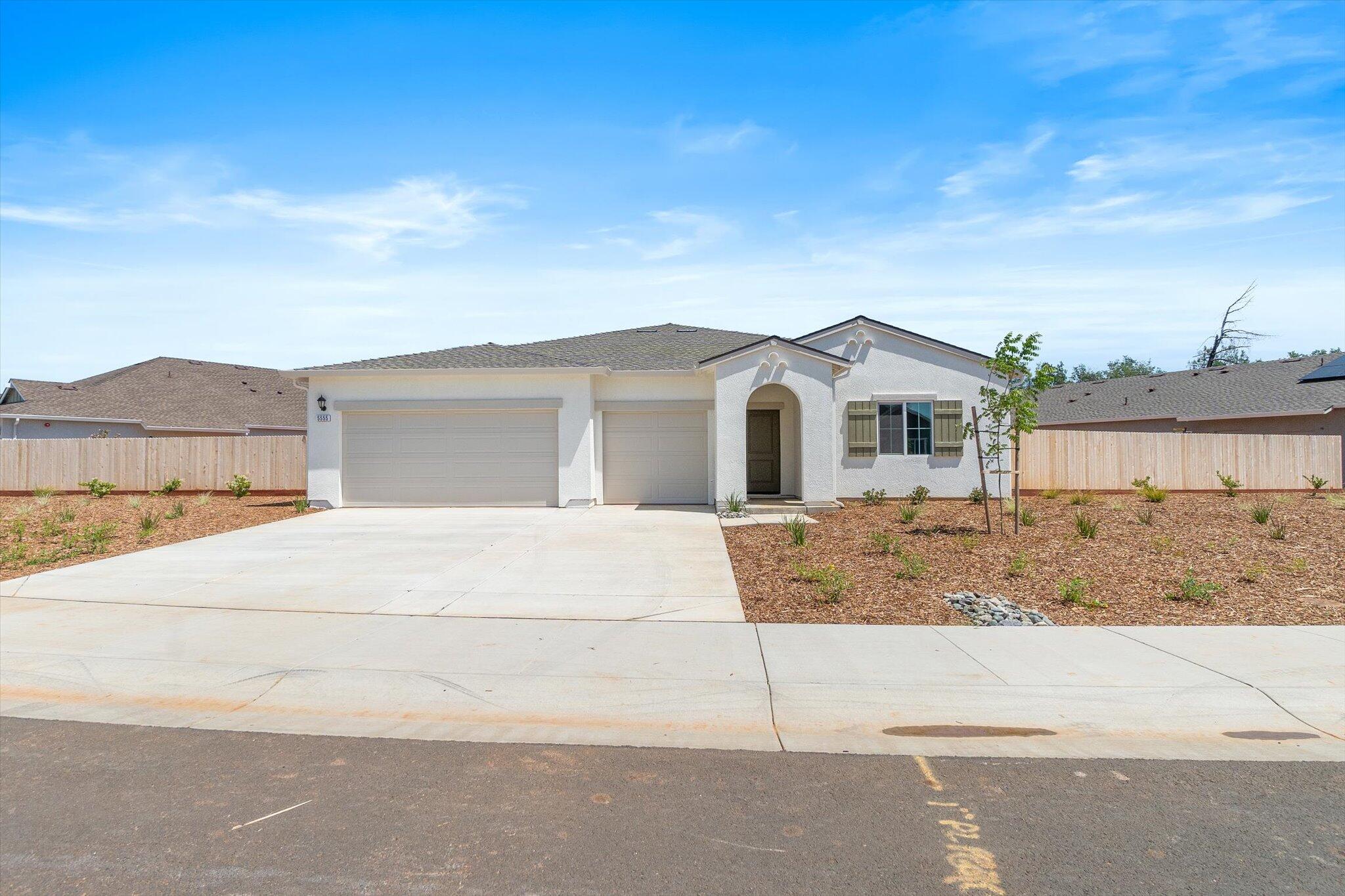 a view of a white house with a yard and large tree