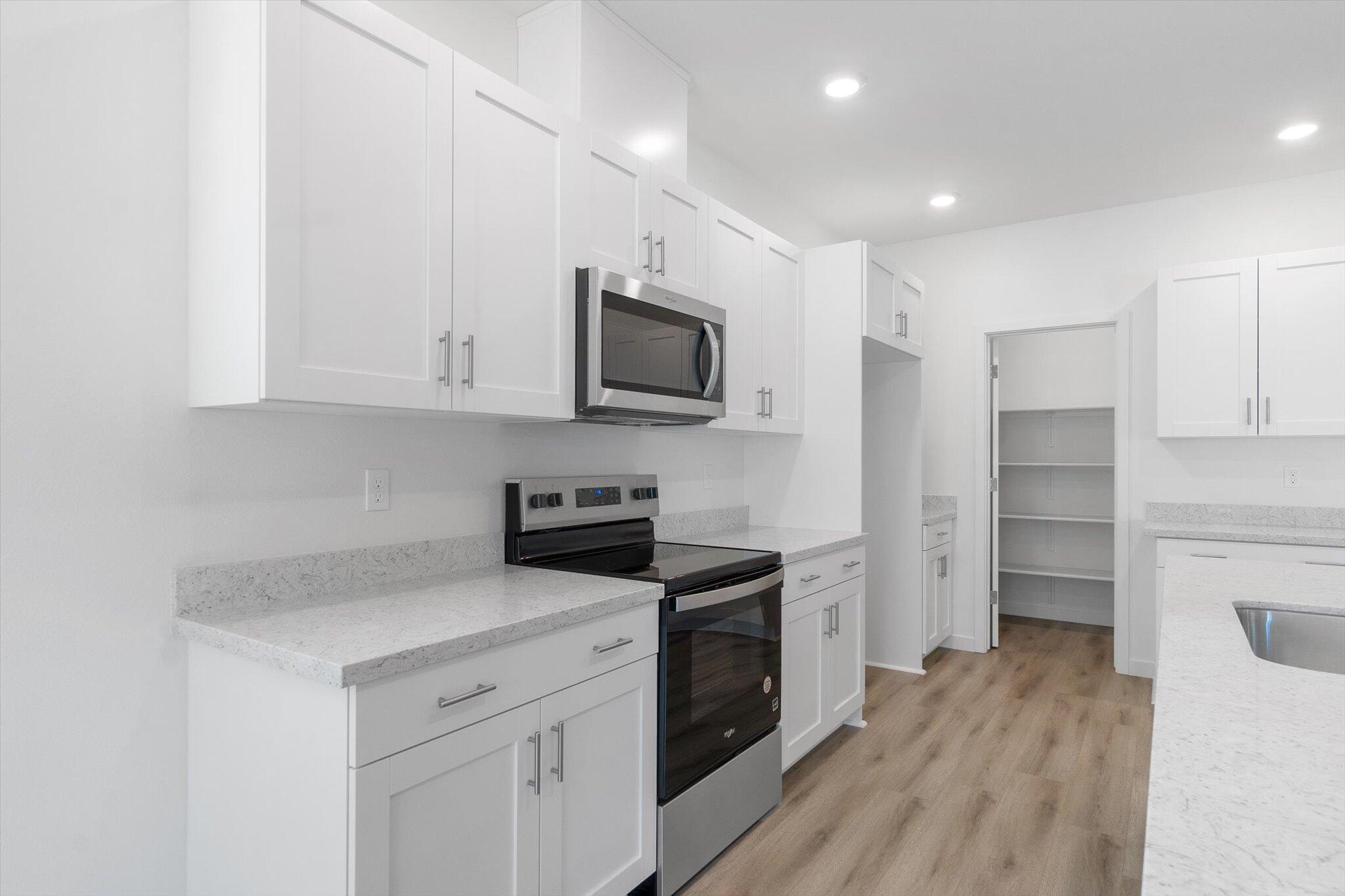 5555 Feathers Avenue Redding, CA 96002 - Photo 6 of 31 a kitchen with a refrigerator stove and white cabinets