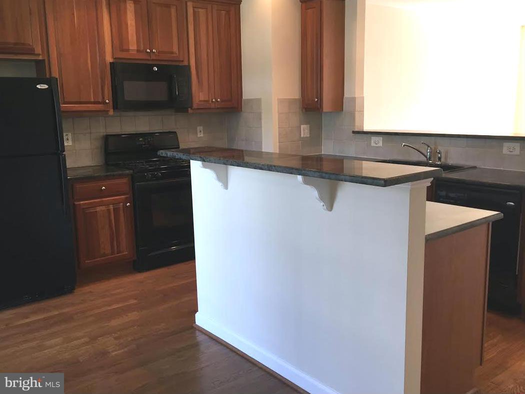 708 Redgate Lane Woodbridge, VA 22191 - Photo 6 of 20 a kitchen with granite countertop a refrigerator and a sink