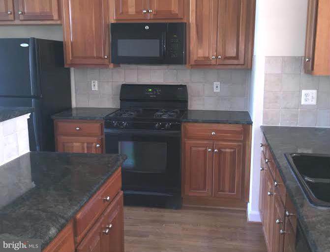 708 Redgate Lane Woodbridge, VA 22191 - Photo 7 of 20 a kitchen with stainless steel appliances granite countertop a stove and a refrigerator