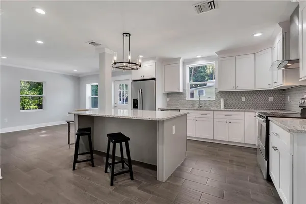 a kitchen with kitchen island granite countertop a sink cabinets and window