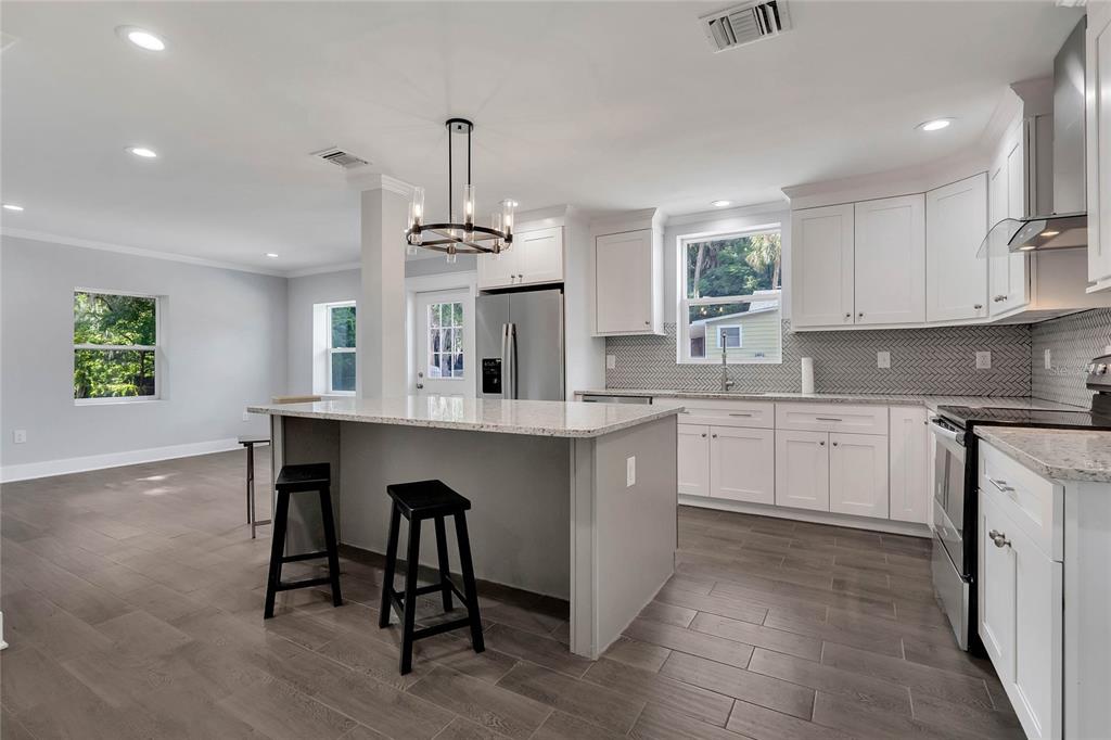 415 South 9th Street Leesburg, FL 34748 - Photo 11 of 37 a kitchen with kitchen island granite countertop a sink cabinets and window
