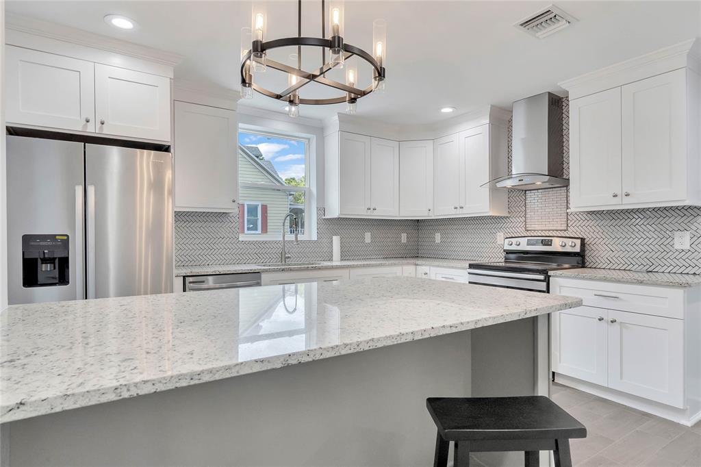 415 South 9th Street Leesburg, FL 34748 - Photo 14 of 37 a kitchen with stainless steel appliances a sink a stove a refrigerator cabinets and wooden floor
