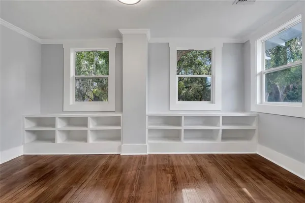 a view of a room with wooden floor and windows