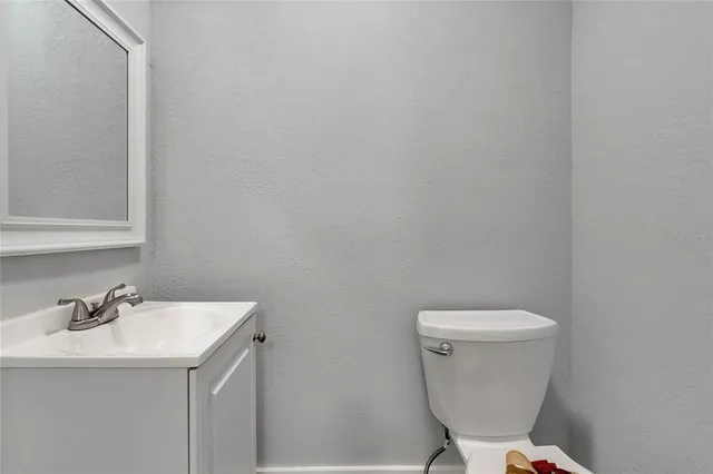 a bathroom with a sink a toilet and a mirror