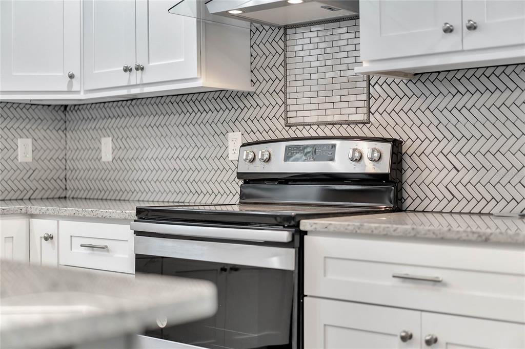 415 South 9th Street Leesburg, FL 34748 - Photo 27 of 37 a kitchen with granite countertop white cabinets and white appliances