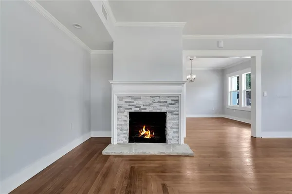 a living room with wooden floor and a fireplace