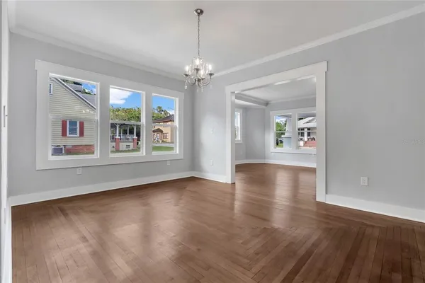 a view of an empty room with window and wooden floor