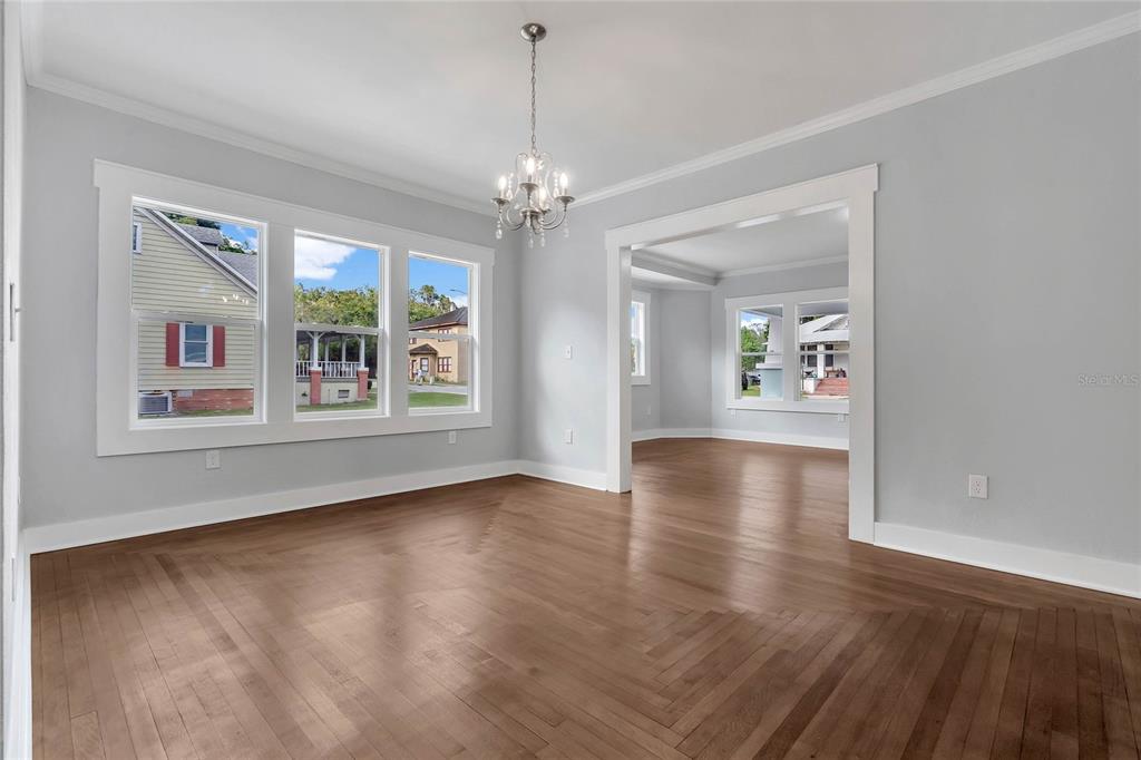 415 South 9th Street Leesburg, FL 34748 - Photo 9 of 37 a view of an empty room with window and wooden floor