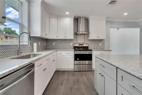 a kitchen with granite countertop white cabinets and appliances