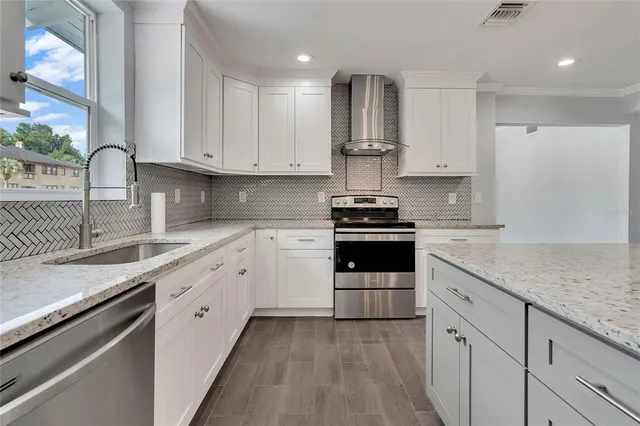 a kitchen with granite countertop white cabinets and appliances