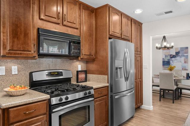 a kitchen with granite countertop wooden cabinets and stainless steel appliances