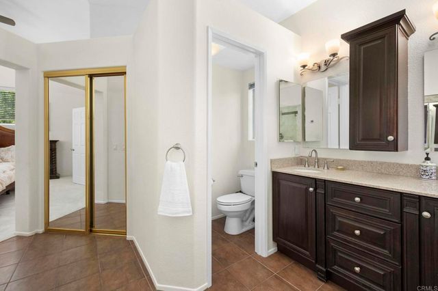 a bathroom with a sink a toilet and a large mirror