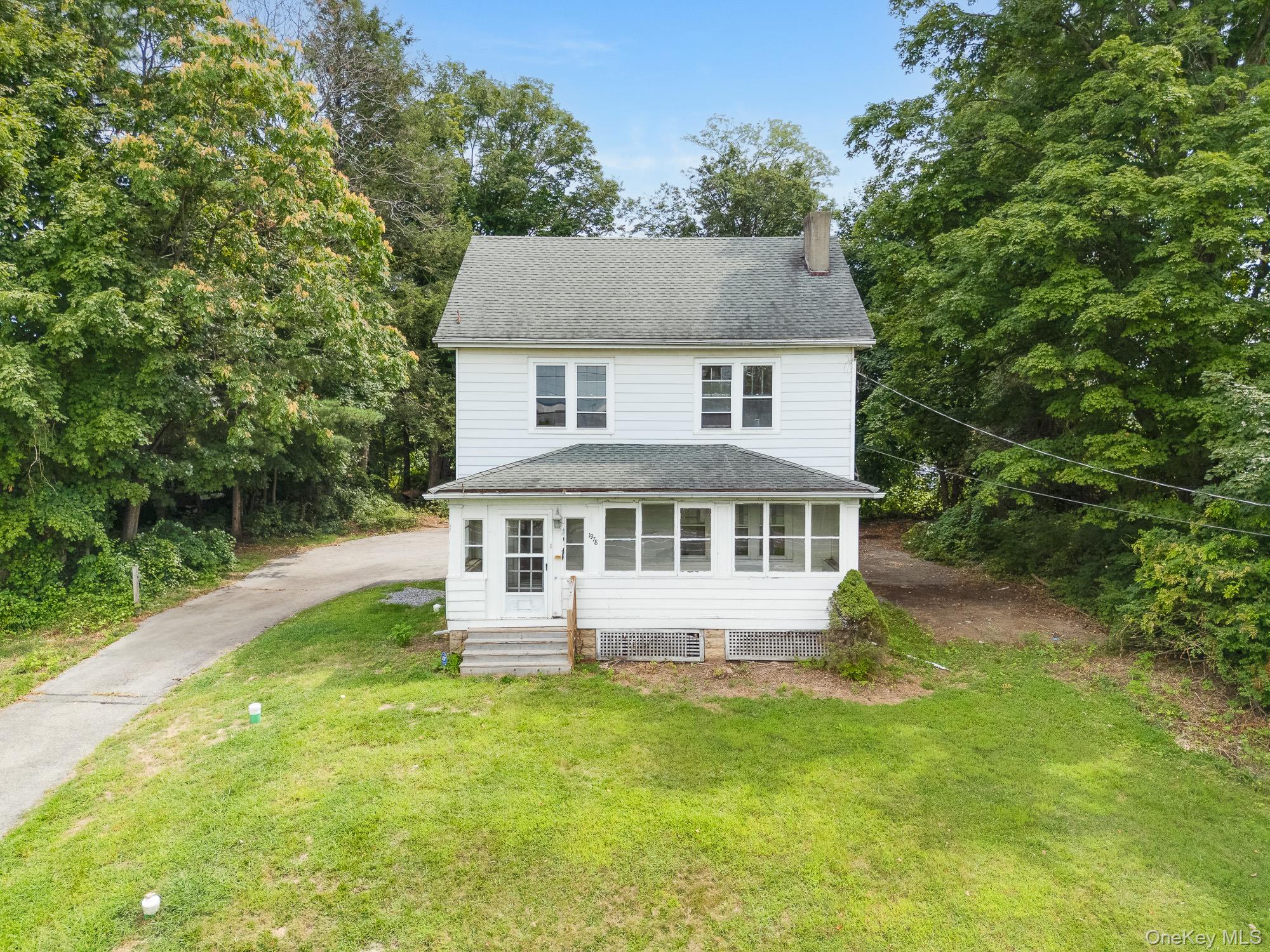 a view of a house with a yard potted plants and large tree